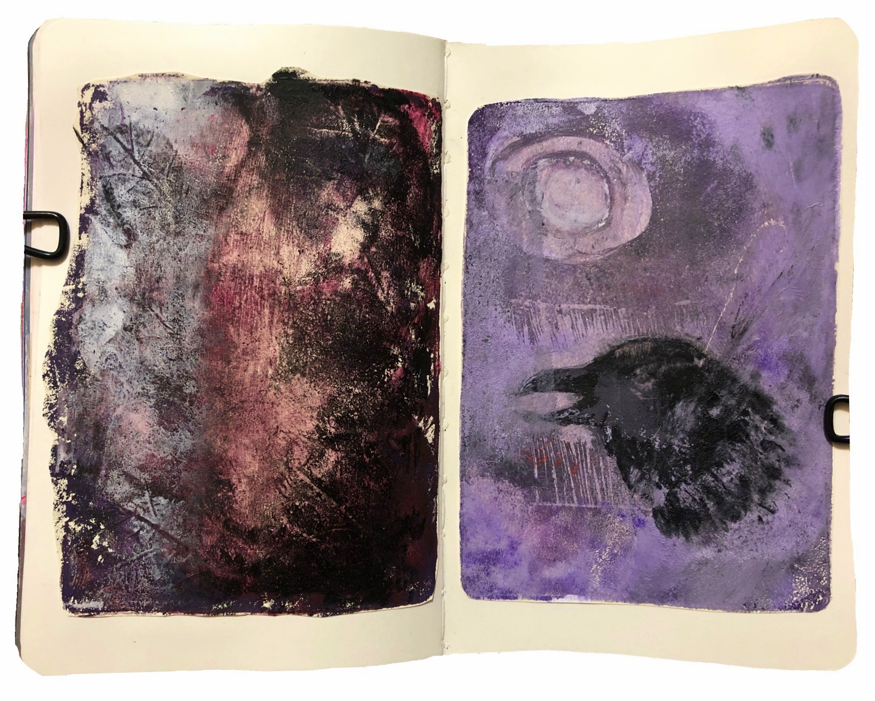 A mixed media art journal page with monoprinting experiments using a gel plate, I used leaves on the left and a linocut stamp I made of a crow on the right.