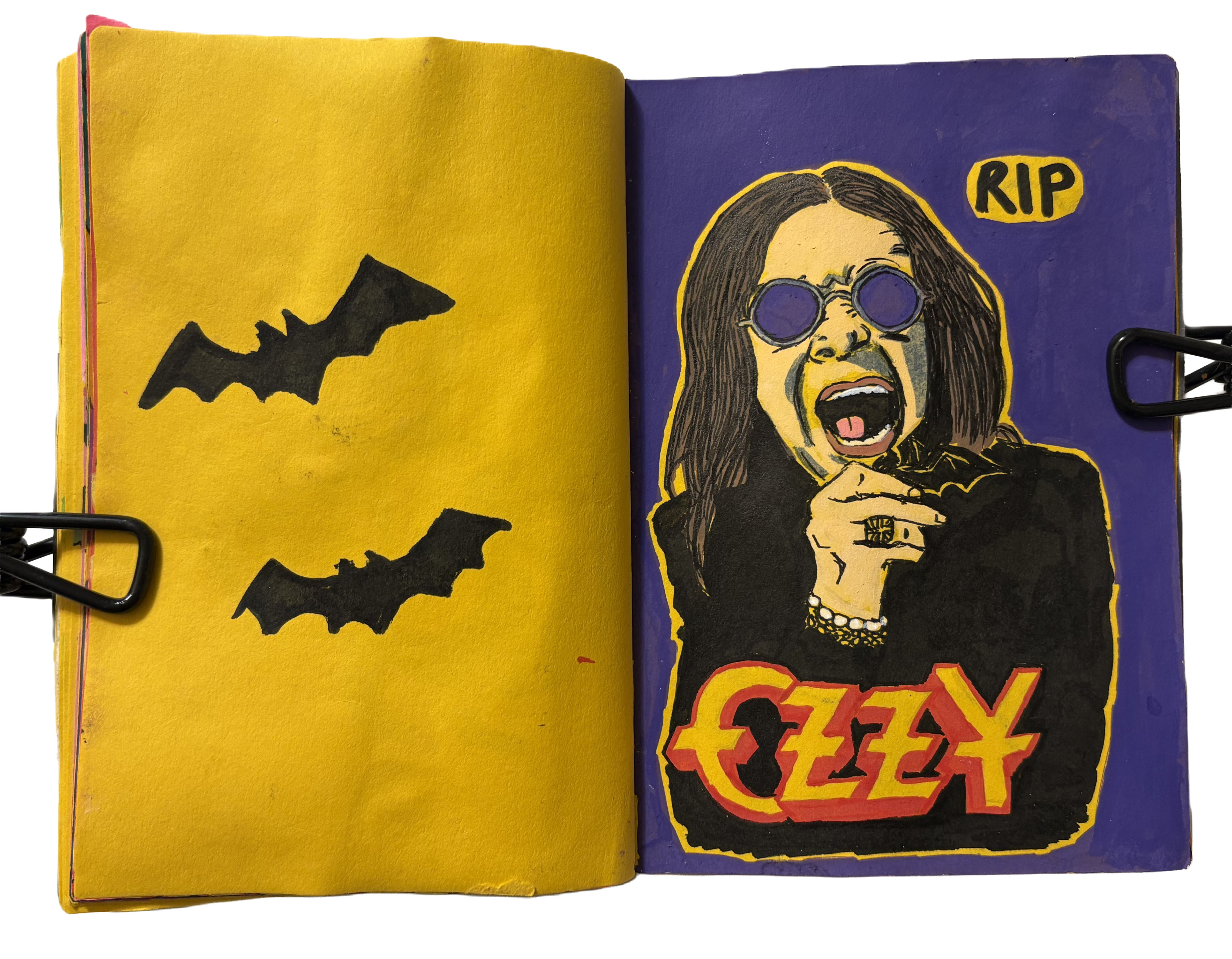 A mixed media art journal page with stamps of black bats next to a tribute illustration of Ozzy Osbourne.